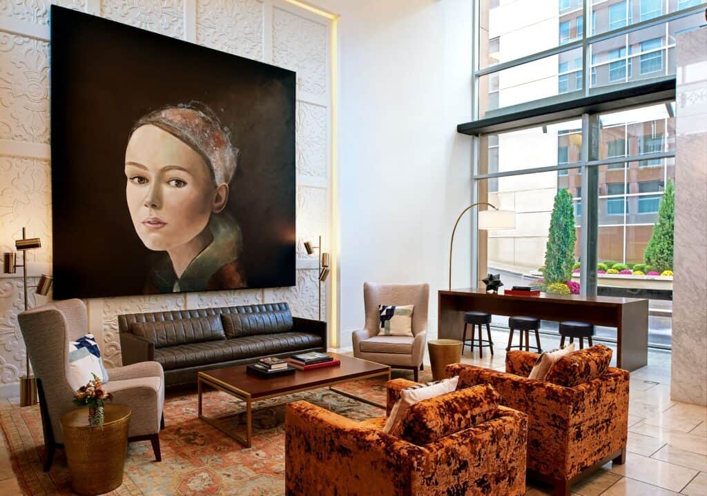 hotel lobby in country club plaza with large painting of a woman and upholstered furniture
