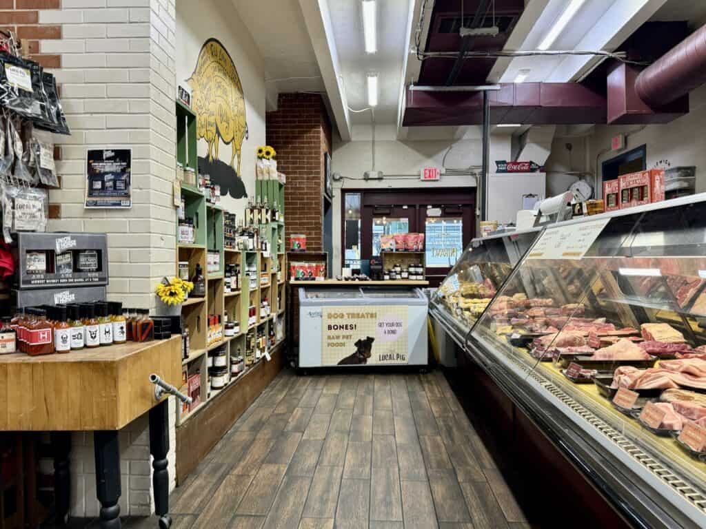 Local Pic butcher shop with wooden floors, a meat counter, and shelves of local Kansas City goods.