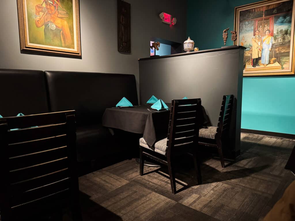 dark dining room at waldo thai restaurant with blue wall and thai artwork