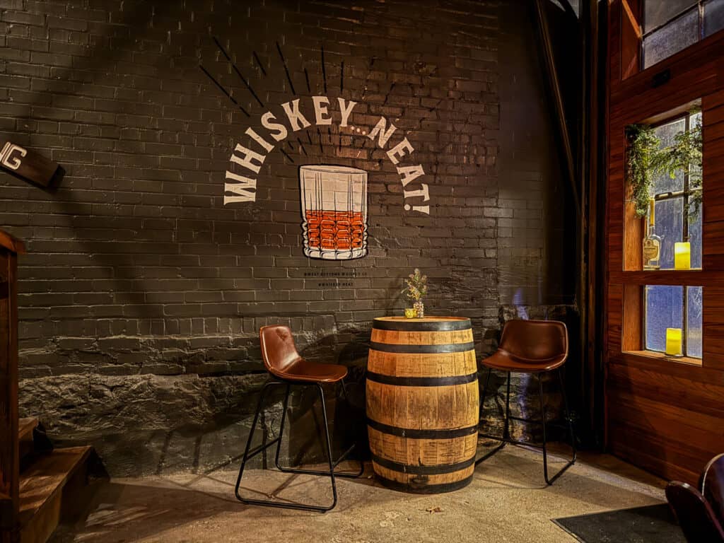 west bottoms whiskey company with wall mural and whiskey barrel table